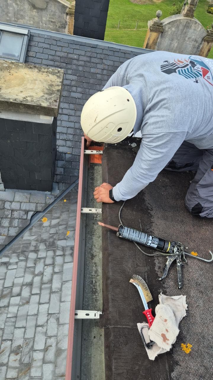 Operario sellando canalones