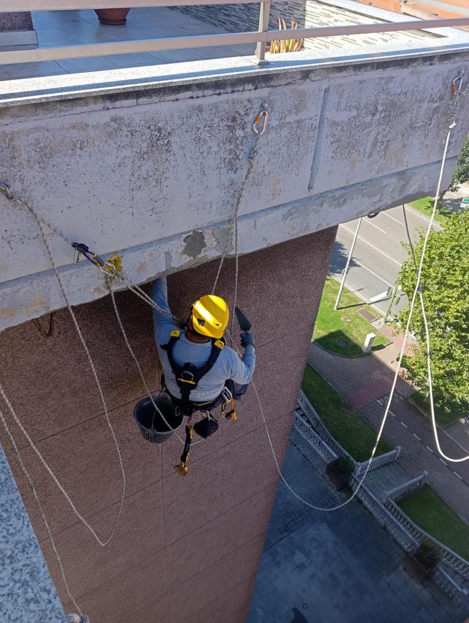 Vista lateral del operario reparando el alero